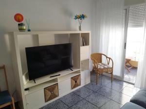 a living room with a television on a white entertainment center at Capitanía frente al mar in Puerto de Mazarrón