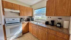 a kitchen with wooden cabinets and a white appliance at Cozy Rooms near Busch Gardens in Tampa