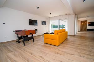 - un salon avec un canapé jaune et une table dans l'établissement Ferienhaus Beata mit privatem Pool in Istrien,Vodnjan, à Svetvinčenat