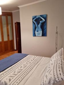 a bedroom with a bed with a painting on the wall at Loft Teis in Vigo