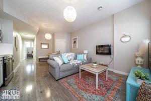 - un salon avec un canapé et une table dans l'établissement Boho Suite - Long Stays - King Bed - Fireplace & WiFi, à Edmonton