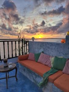 een woonkamer met een bank en een zonsondergang bij Pwani House - Lamu Seafront in Lamu