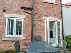 a table and chairs in front of a brick building at Coastal Retreat, The Bay in Filey