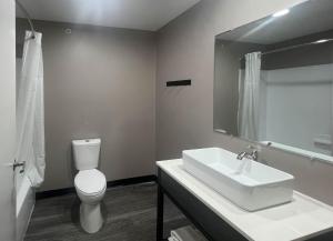Studio 6 Oklahoma City, OK South في مدينة اوكلاهوما: حمام مع حوض ومرحاض ومرآة