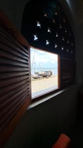 Cette chambre dispose d'une fenêtre offrant une vue sur la plage. dans l'établissement Pwani House - Lamu Seafront, à Lamu