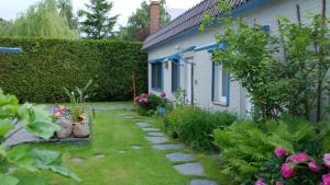 a garden with a stone path next to a house at Ferienhof Marlin - Ferienhaus Stralsund in Solkendorf