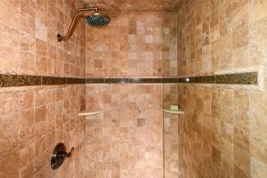 La salle de bains est pourvue d'une douche et de carrelage brun. dans l'établissement Relax in Comfort with Fairway Views at Silverado North Course, à Napa
