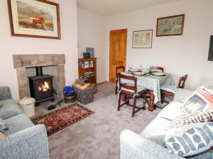 a living room with a fireplace and a table and chairs at Appletree Cottage in Richmond