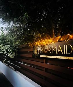 a sign that reads mermaid on a wooden bench at Mermaid Holiday Apartments in Mandria