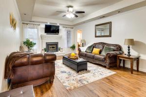 a living room with a leather couch and a fireplace at Spacious Madison Vacation Rental with Backyard! in Madison