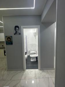 een witte badkamer met een toilet en een deuropening bij Casa vacanze QS 10 in Napels