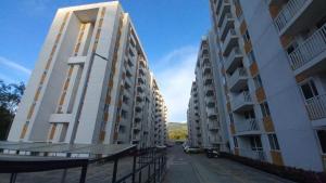 dos edificios de apartamentos blancos y altos en una calle en Apartamento cómodo en Villeta en Villeta