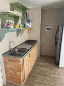 a kitchen with a sink and a stove at Apartamento cómodo en Villeta in Villeta +3 photos