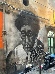 een muur met een groot gezicht erop geschilderd bij Casa vacanze QS 10 in Napels