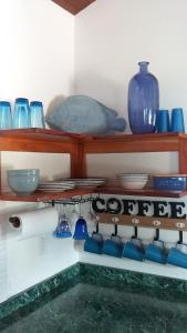 a shelf with blue vases and bowls on a wall at Bella Vita Casitas in Placencia Village