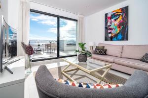 uma sala de estar com um sofá e uma mesa em LAE212D - Mirador Estepona hills by Roomservices em Estepona