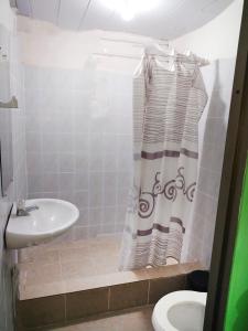 uma casa de banho com um lavatório, um WC e um chuveiro em Divino Niño Hotel em Letícia