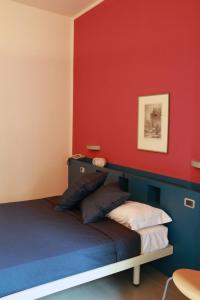 a bedroom with a bed with a red wall at Hotel Kursaal BB in Salsomaggiore Terme