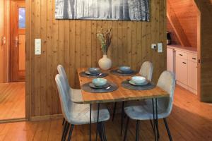una mesa de madera con sillas y un jarrón. en Nur-Dach-Haus am Alfsee en Rieste