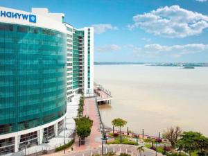 a large building next to a large body of water at Ecusuites Riverfront One Vista al Río Jacuzzi Hidro in Guayaquil