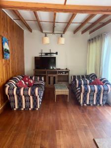 ein Wohnzimmer mit 2 Sofas und einem TV in der Unterkunft CASA in Pucón