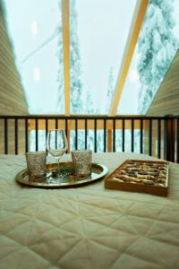 una mesa con un plato de comida y una copa de vino en Villa Auroras Karhu, en Syöte