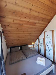 Cama en habitación con techo de madera en Mikael's Bed & Spa apartment, en Sandefjord