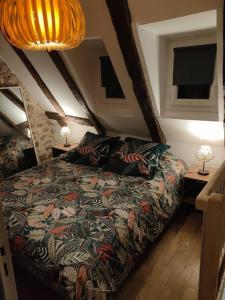 een slaapkamer met een bed met een kleurrijke deken bij La maisonette de Raphaël in Saint-Mamet-la-Salvetat