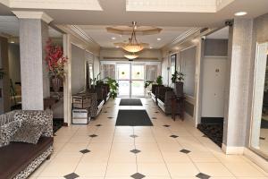 a hallway of a lobby with couches and a rug at Savai Hotel in Overland Park