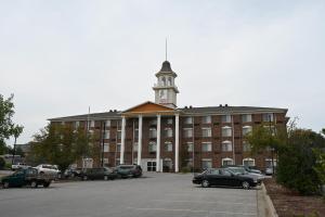 a large building with a clock tower on top of it at Savai Hotel in Overland Park