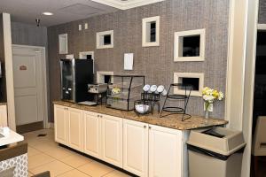 a kitchen with a counter with flowers on it at Savai Hotel in Overland Park