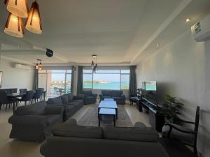ein großes Wohnzimmer mit Sofas und einem TV in der Unterkunft Fun Beach - Durrat AL Arous in Durrat Al-Arus