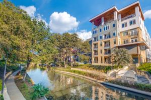 a building next to a river in a city at Radiant condo on the Riverwalk 1325 in San Antonio