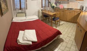 Un dormitorio con una cama roja con toallas. en Maison d'Ax Venice Center, en Venecia