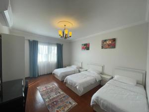 a room with three beds and a chandelier at Fun Beach - Durrat AL Arous in Durat  Alarous