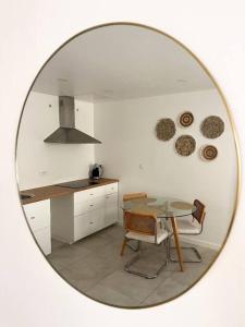un miroir reflétant une cuisine avec une table et une cuisinière dans l'établissement Les Bords de l'Estaque x Le refuge de Cézanne, à Marseille