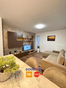 a living room with a couch and a tv at Deluxe Cozy Apartments - Coresi Mall #Brasov in Braşov