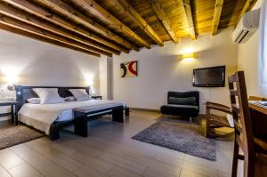 a bedroom with a bed and a tv and a chair at YIT Abentofail in Guadix