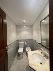 ein Badezimmer mit einem Waschbecken, einem WC und einem Spiegel in der Unterkunft Fun Beach - Durrat AL Arous in Durrat Al-Arus