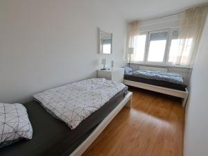 Un dormitorio con dos camas y dos ventanas. en Charming Celje City Center Apartment, en Celje