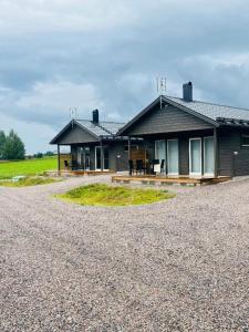 a house with a gravel driveway in front of it at Överkalix Jockfall Holiday Home in Jock