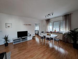 a living room with a white table and a television at Charming Celje City Center Apartment in Celje
