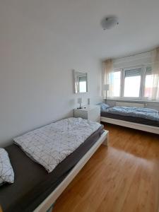 Un dormitorio con dos camas y dos ventanas. en Charming Celje City Center Apartment, en Celje