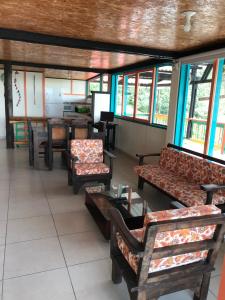 una sala de espera con sofás, mesas y ventanas en Reserva Natural Finca La Cabaña, en Dosquebradas