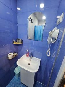 a blue bathroom with a sink and a mirror at Cozy Apartment in Old Tbilisi in Tbilisi City