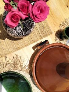 マラケシュにあるRiad Siena IIのテーブルに座るピンクのバラが詰まった花瓶