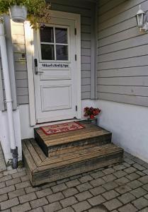una puerta blanca con una alfombra de bienvenida frente a una casa en Bubbles Breakfast and Spa en Sandefjord