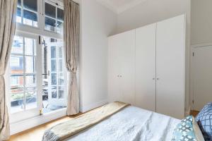 1 dormitorio con cama y ventana en Renovu Premium Homes in Kensington, en Londres