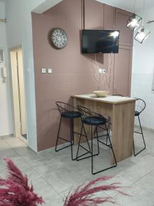 Il dispose d'une cuisine avec un îlot doté de chaises et d'une télévision. dans l'établissement AniBo Studios and Apartments ZERO POINT 52, à Thessalonique