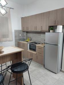uma cozinha com um frigorífico branco e armários de madeira em AniBo Studios and Apartments ZERO POINT 52 em Tessalônica